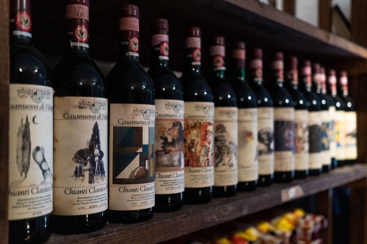A single red wine bottle on a dark shelf