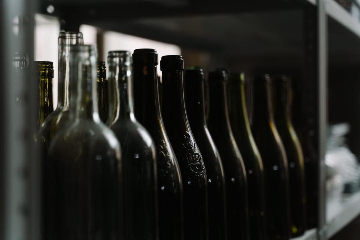 A wine bottle on a dark shelf in a still room
