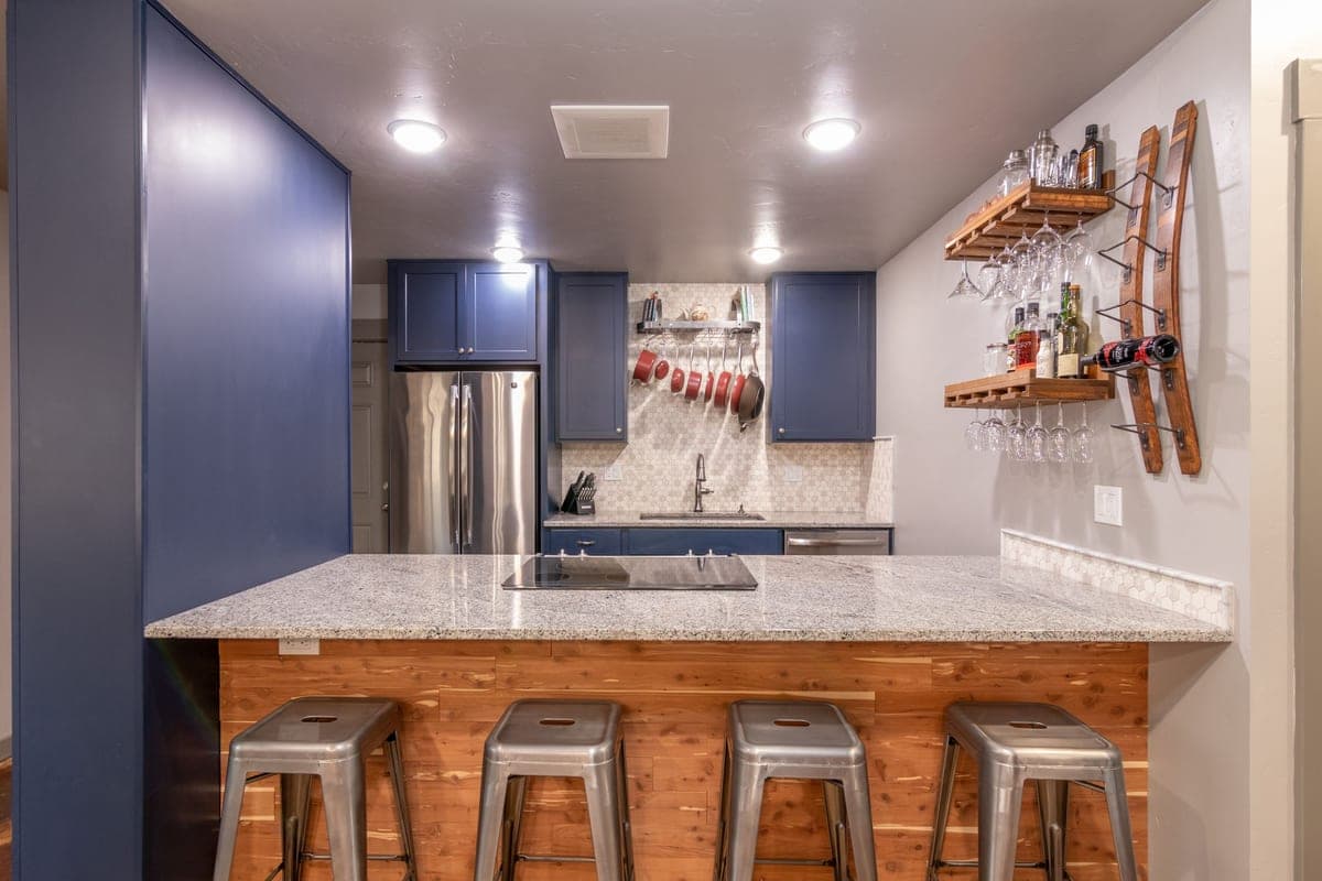 A contemporary kitchen with a stone island and bar stools