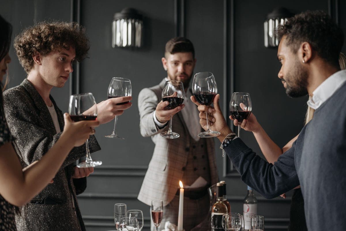 People raising wine glasses in a toast around a table