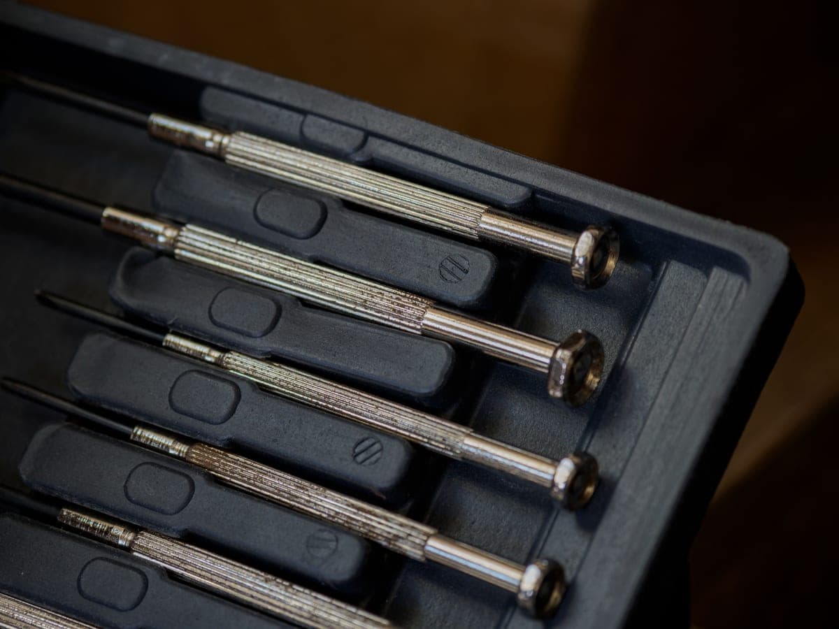 Hands using a screwdriver to work on an appliance