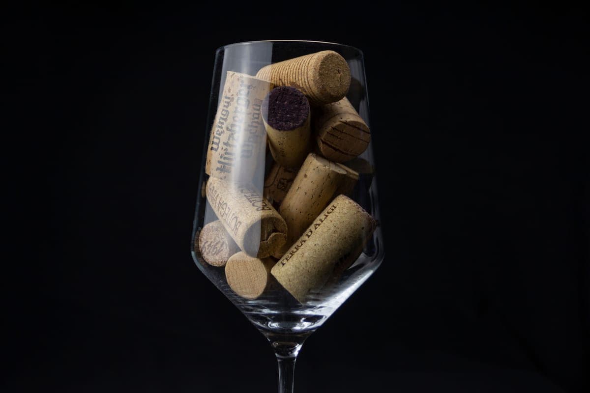Wine corks gathered in a glass against a dark background