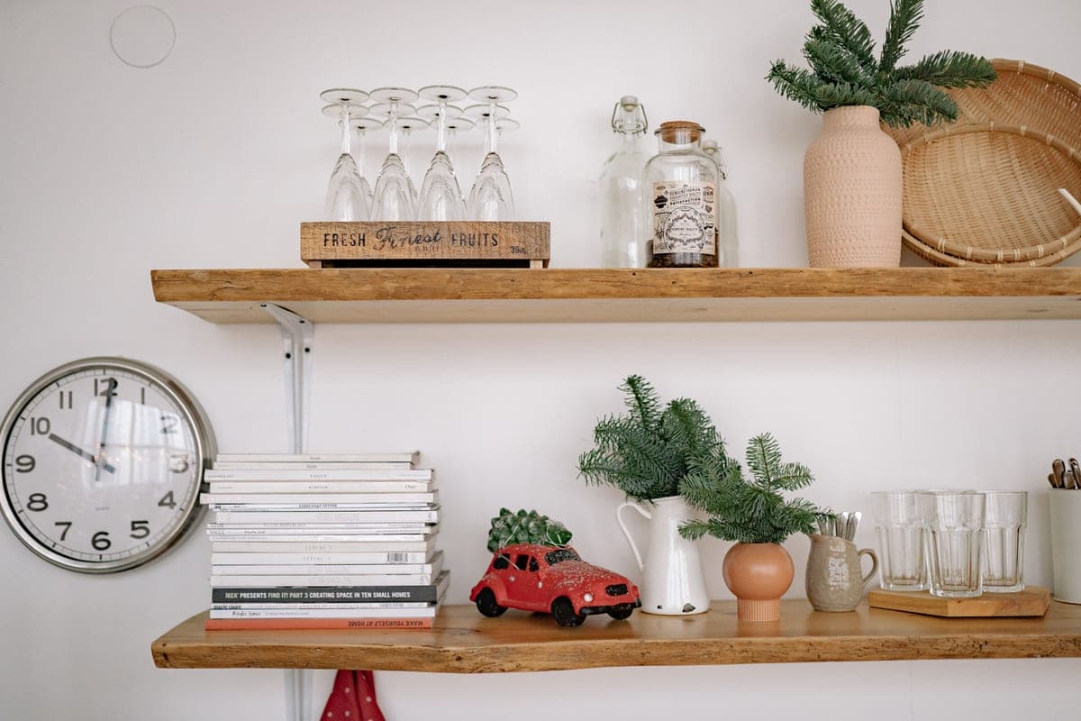 Rustic wooden shelves holding books, glassware and greenery