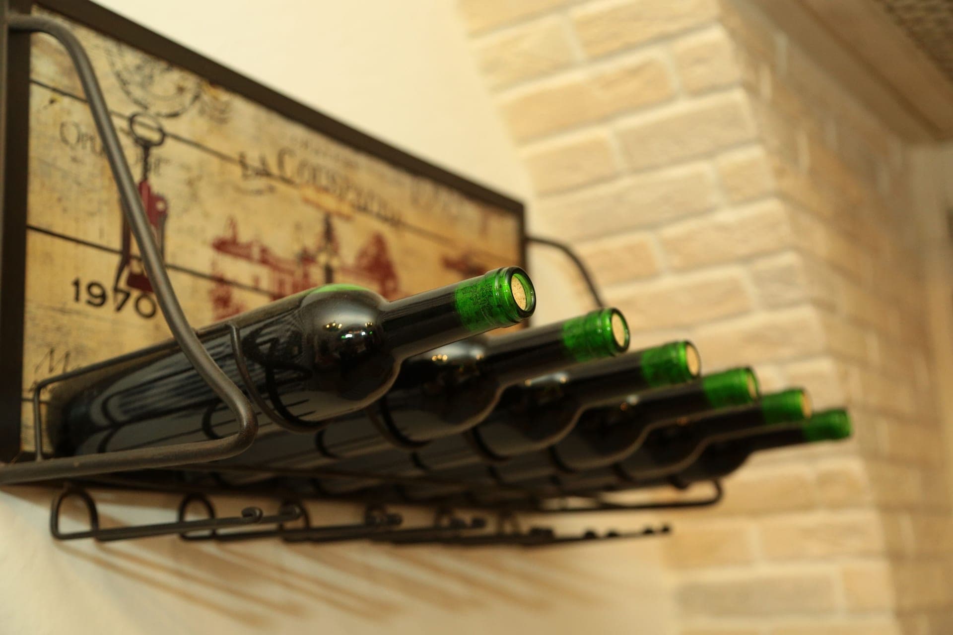 Green wine bottles stored on a shelf in a compact kitchen
