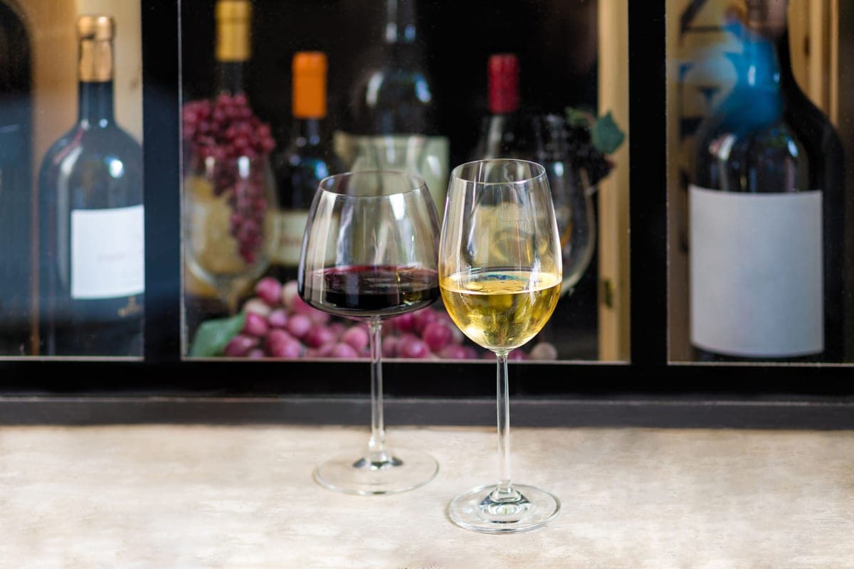 A glass of red wine and a glass of white wine side by side
