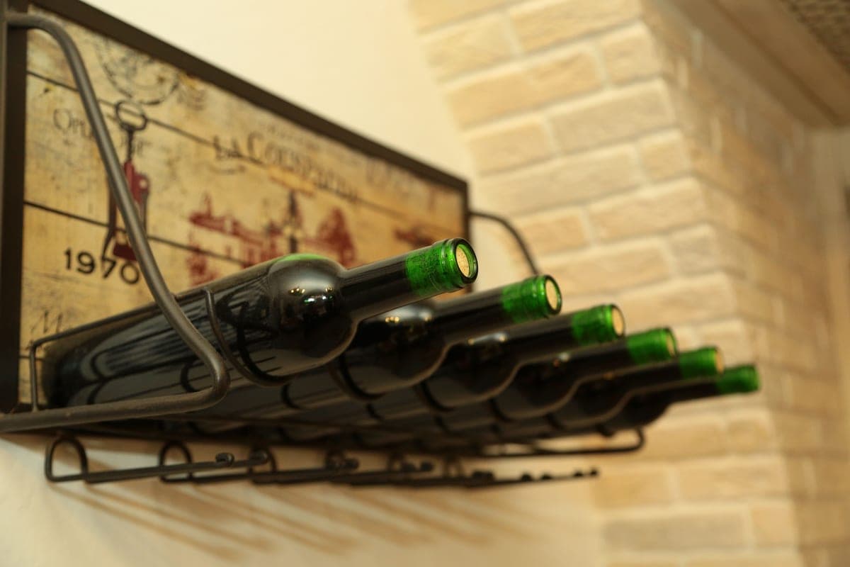 Wine bottles arranged on a rack against a rustic wall