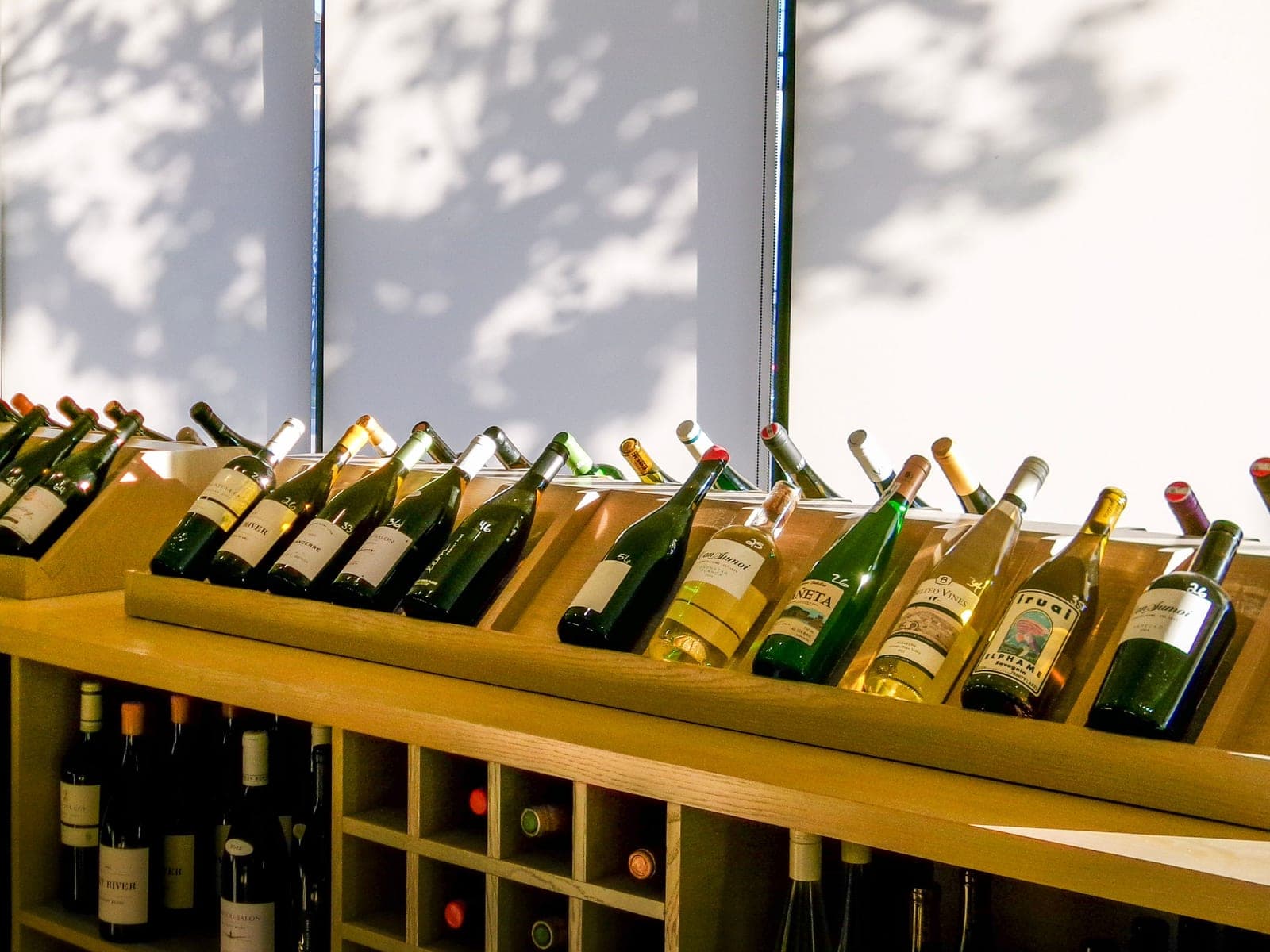 Wine bottles resting on their sides in a wooden storage rack