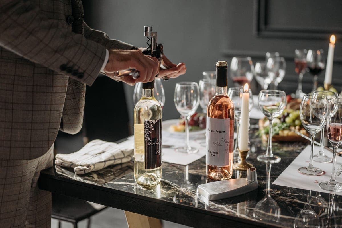 A wine bottle and corkscrew on a wooden table