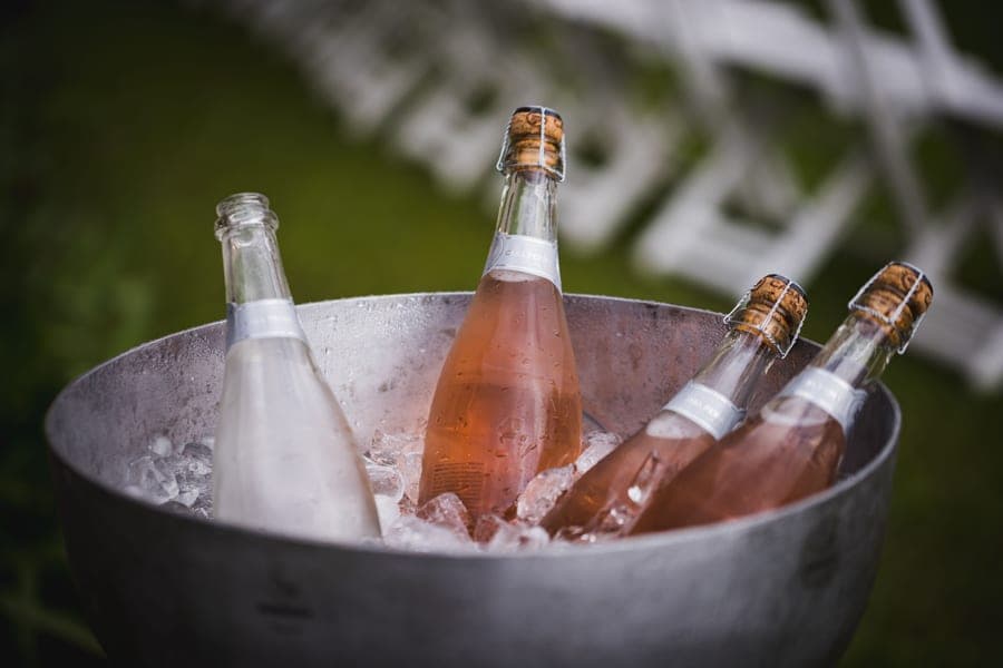 A wine bottle standing in an ice bucket